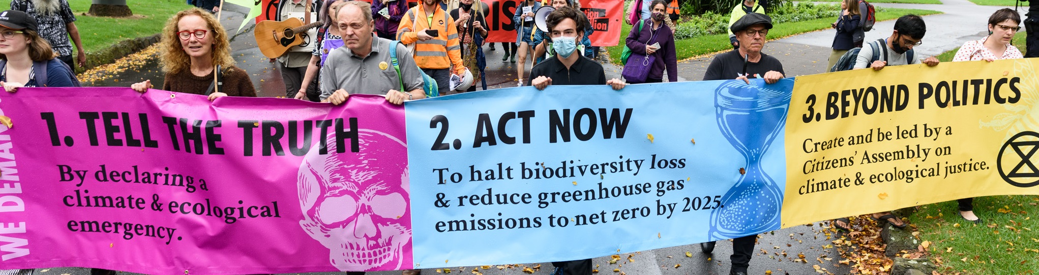 XR activists holding a banner listing XR's 3 demands