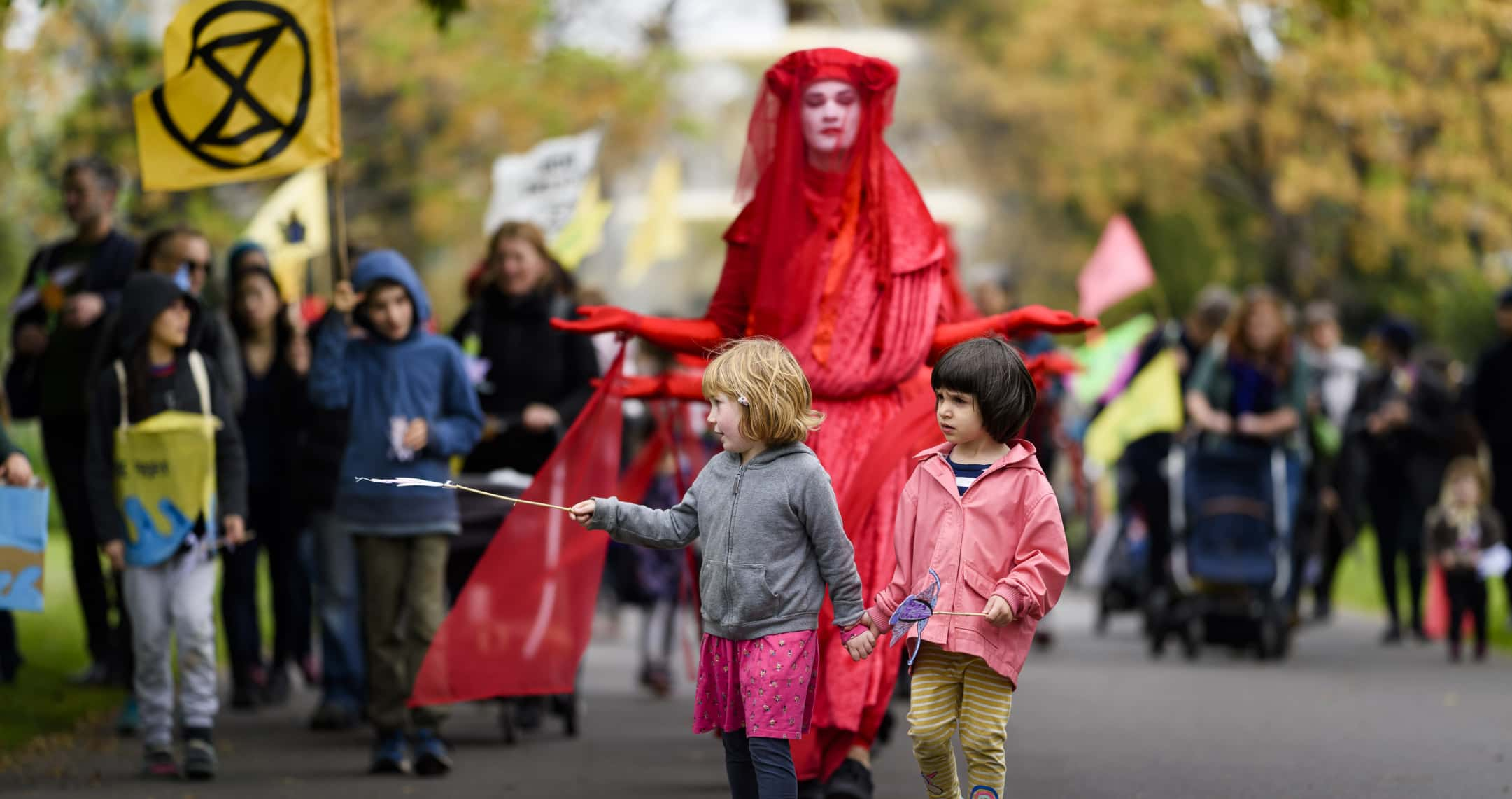 Protesters including children and an adult in 'Red Rebel' costume